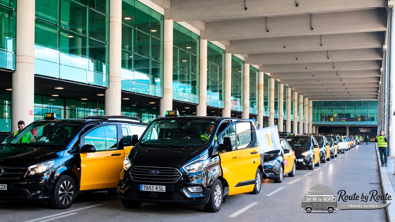 Taxis negros y amarillos de Barcelona haciendo cola en la parada oficial bajo la marquesina de la terminal del aeropuerto de El Prat