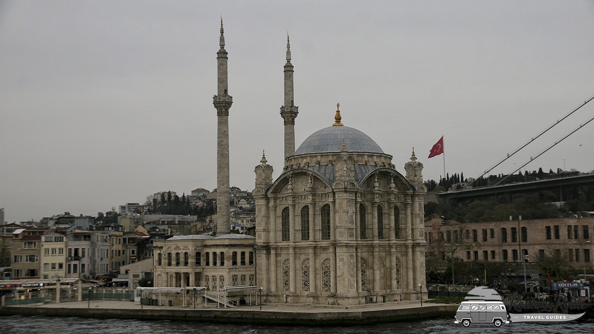Mezquita de Ortaköy con sus dos minaretes junto al Bósforo y el puente al fondo, vista desde el agua
